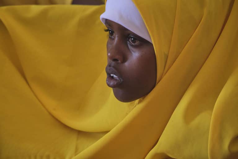 Nærbilde av ung jente i gult sjal.