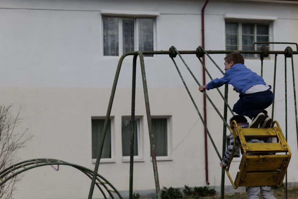 2 gutter i høy fart på en huske utenfor et dagsenter for barn på flukt fra Ukraina