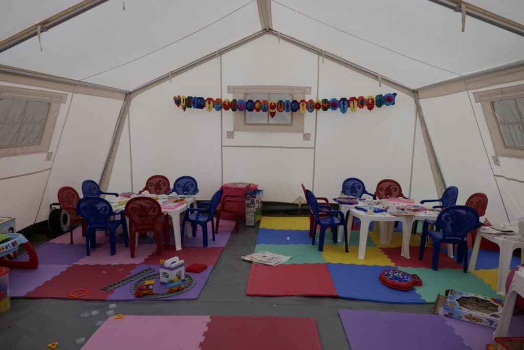 Et telt fylt med stoler, bord og leker til barn, på grensen mellom Ukraina og Romania