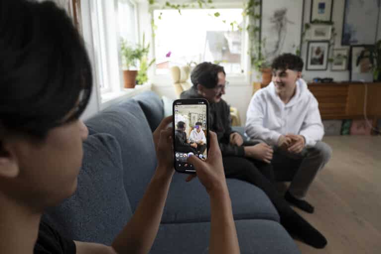 En ungdom tar bilde/snap av to andre ungdommer med snapchat-filter