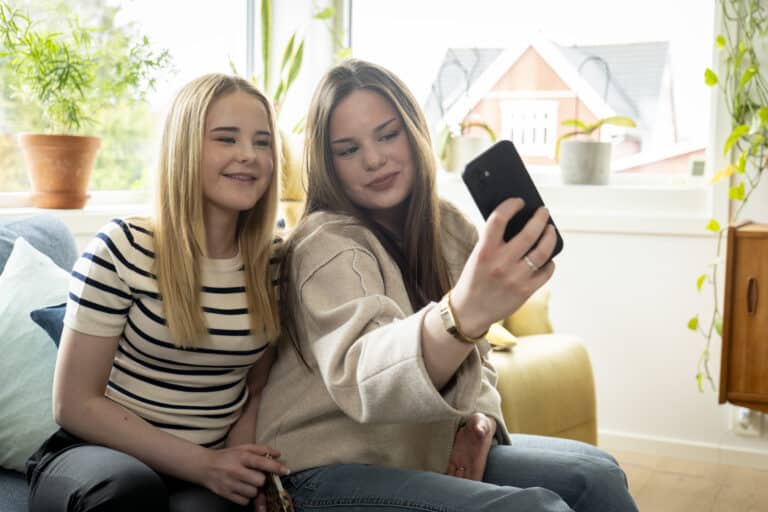 To ungdommer tar en selfie i en stue