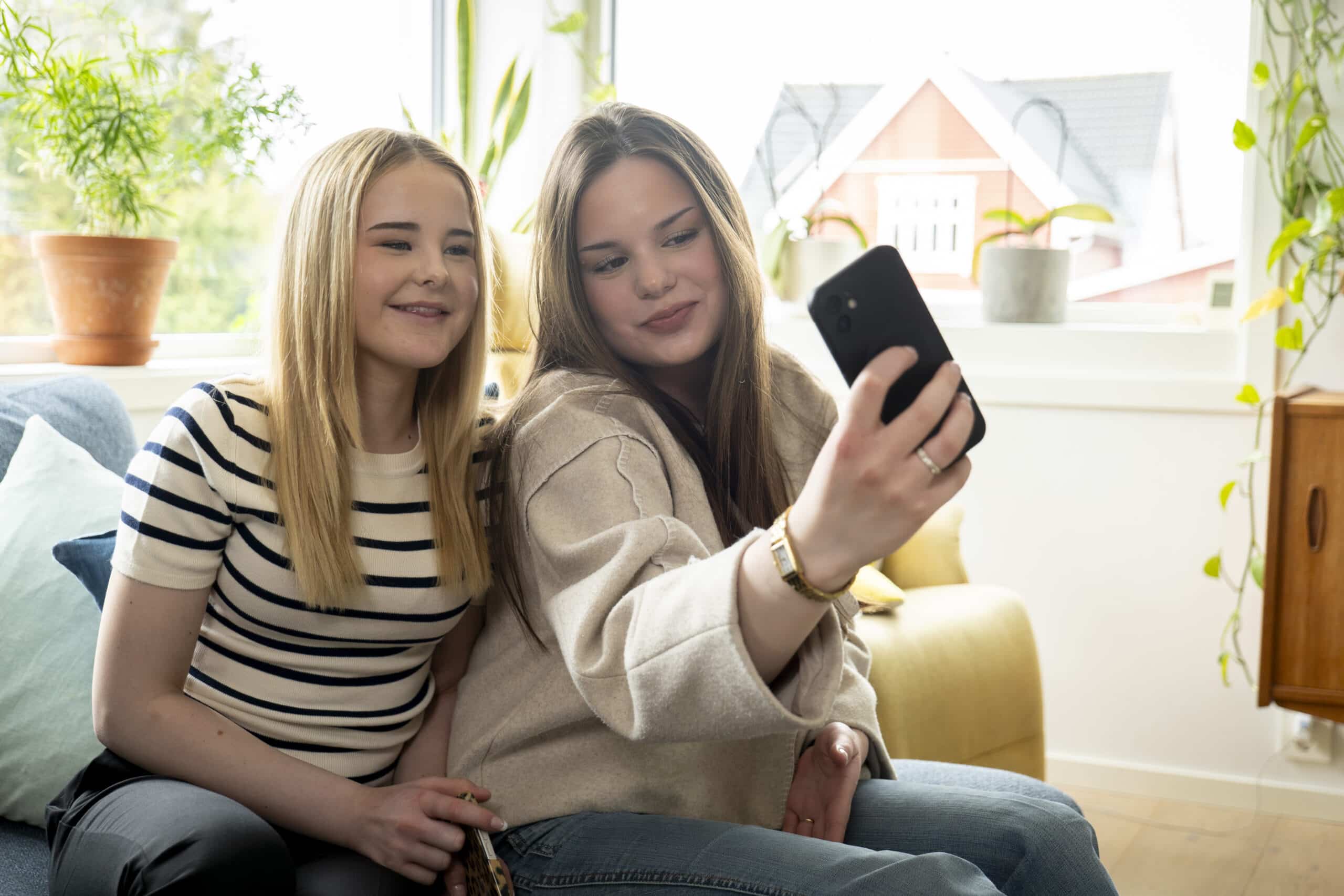 To ungdommer tar en selfie i en stue
