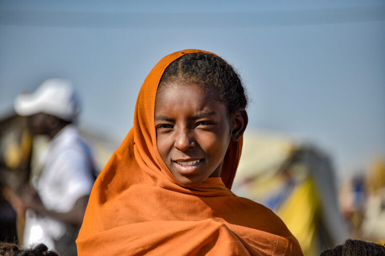 Konflikten i Sudan: Ei jente kledd i oransje kikker inn i kamera