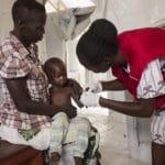 Foto av barn på ett år som testes for malaria av Redd Barna ansatt i Uganda. Bistand nytter!