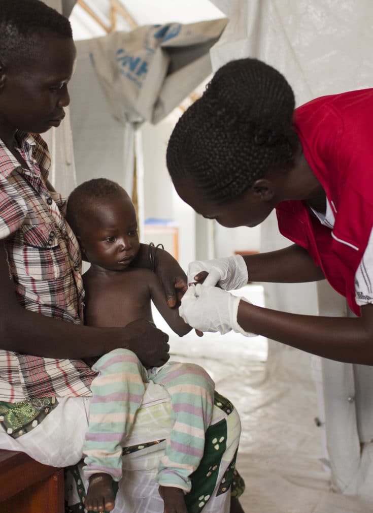 Foto av barn på ett år som testes for malaria av Redd Barna ansatt i Uganda.