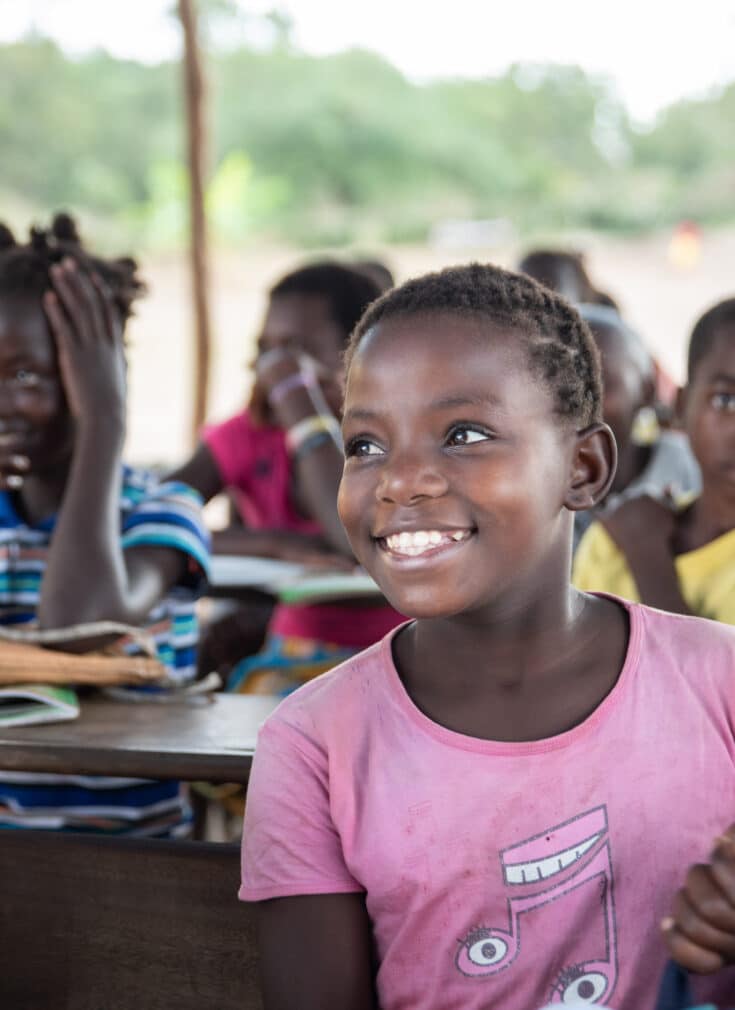 Glade elever som sitter på skolebenken i Mozambique