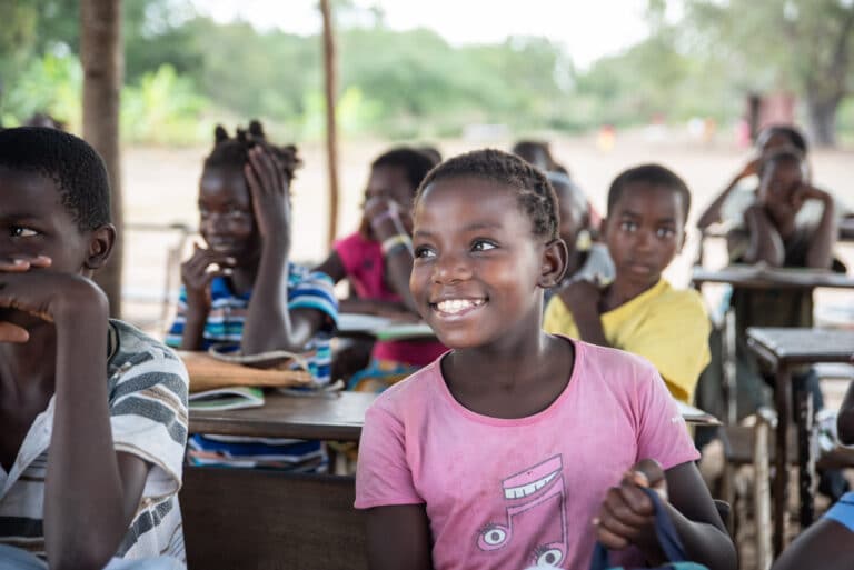 Glade elever som sitter på skolebenken i Mozambique