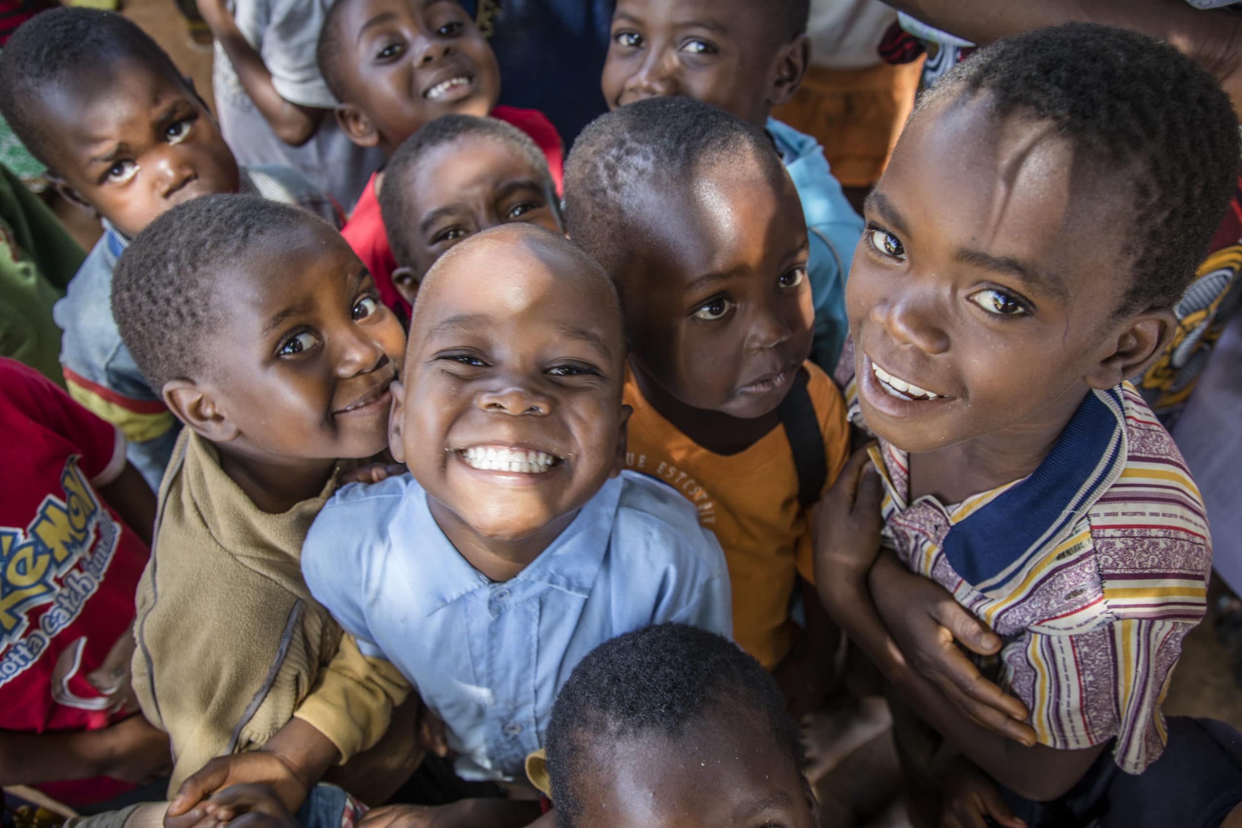 En gruppe barn smiler og kikker opp i kamera
