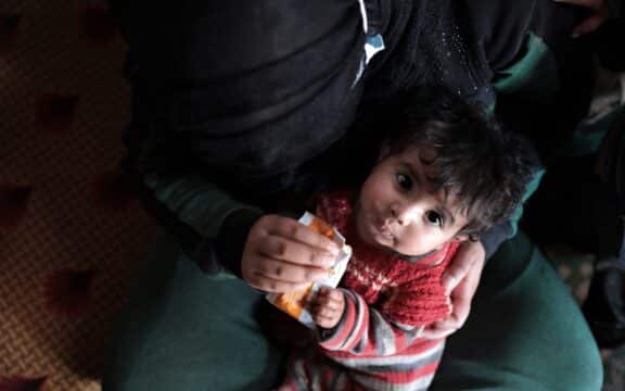 Foto av 10 måneder gammel baby i Syria som får mat på mammas fang_TV-aksjonen 2023 Redd Barna