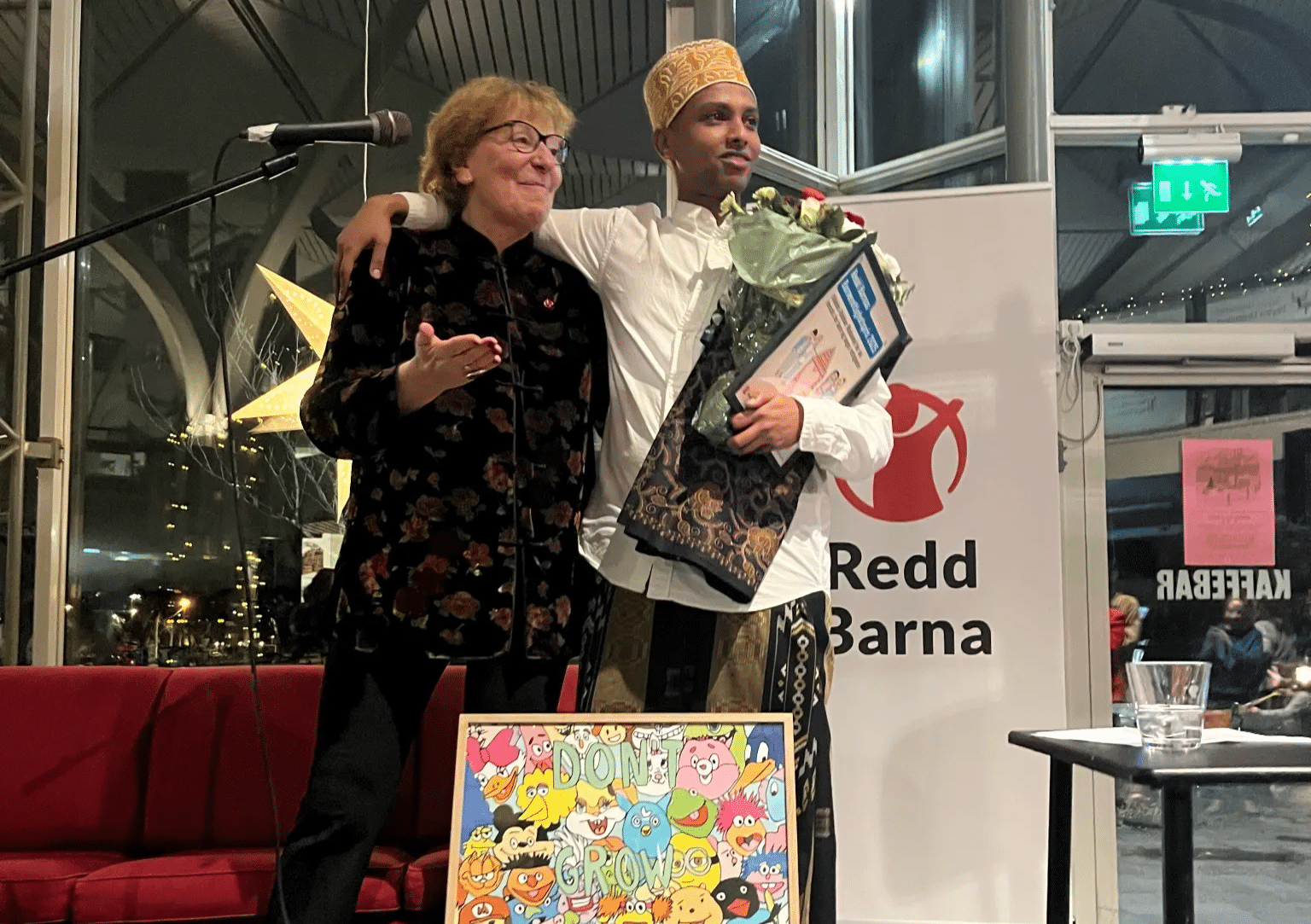 Abdinor Mahamed står sammen med Marianne Borgen og har motatt pris, blomster og et kunstverk