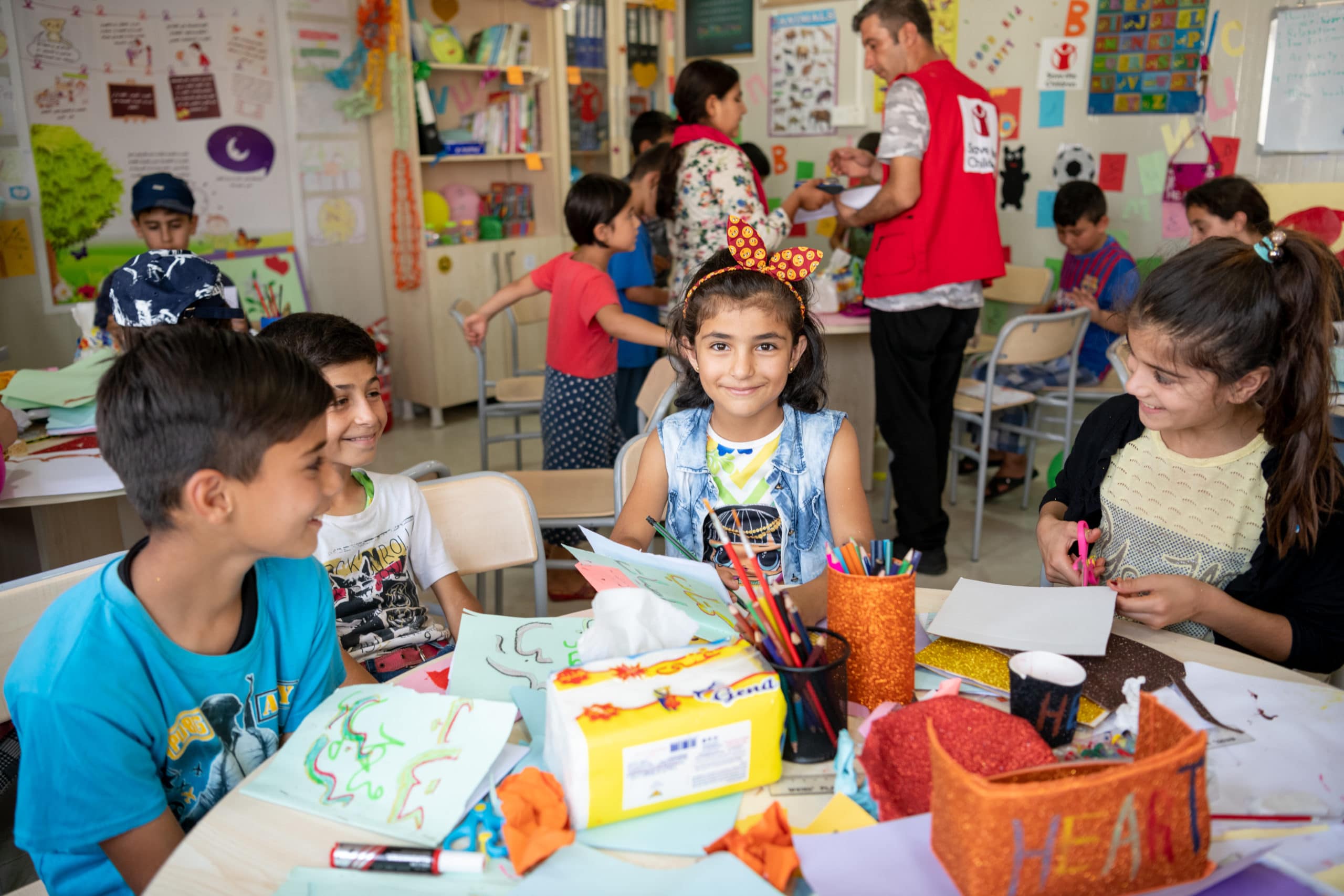 En gruppe syriske flyktninger sitter og tegner ved et bord
