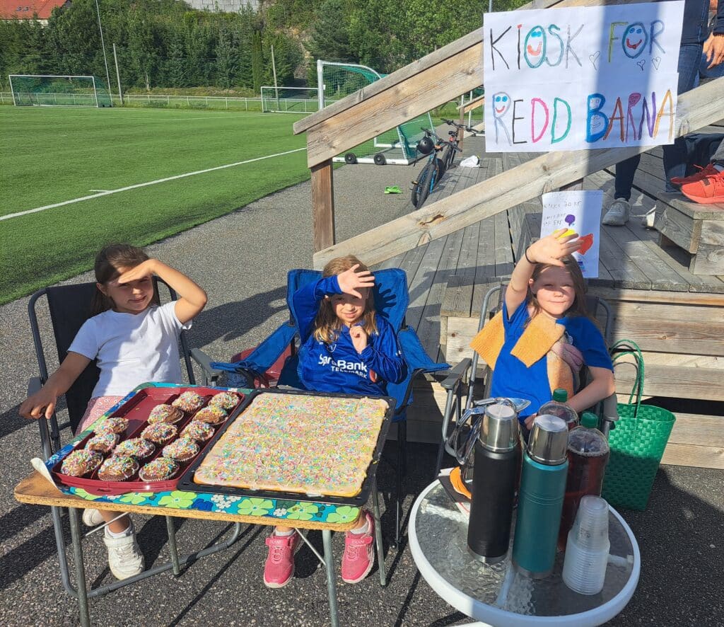 Barn koser seg i solen og holder basar der de selger kaffe, saft, kake og muffins.