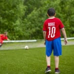 En gutt med draktnummer 10 står med ryggen til på fotballbanen