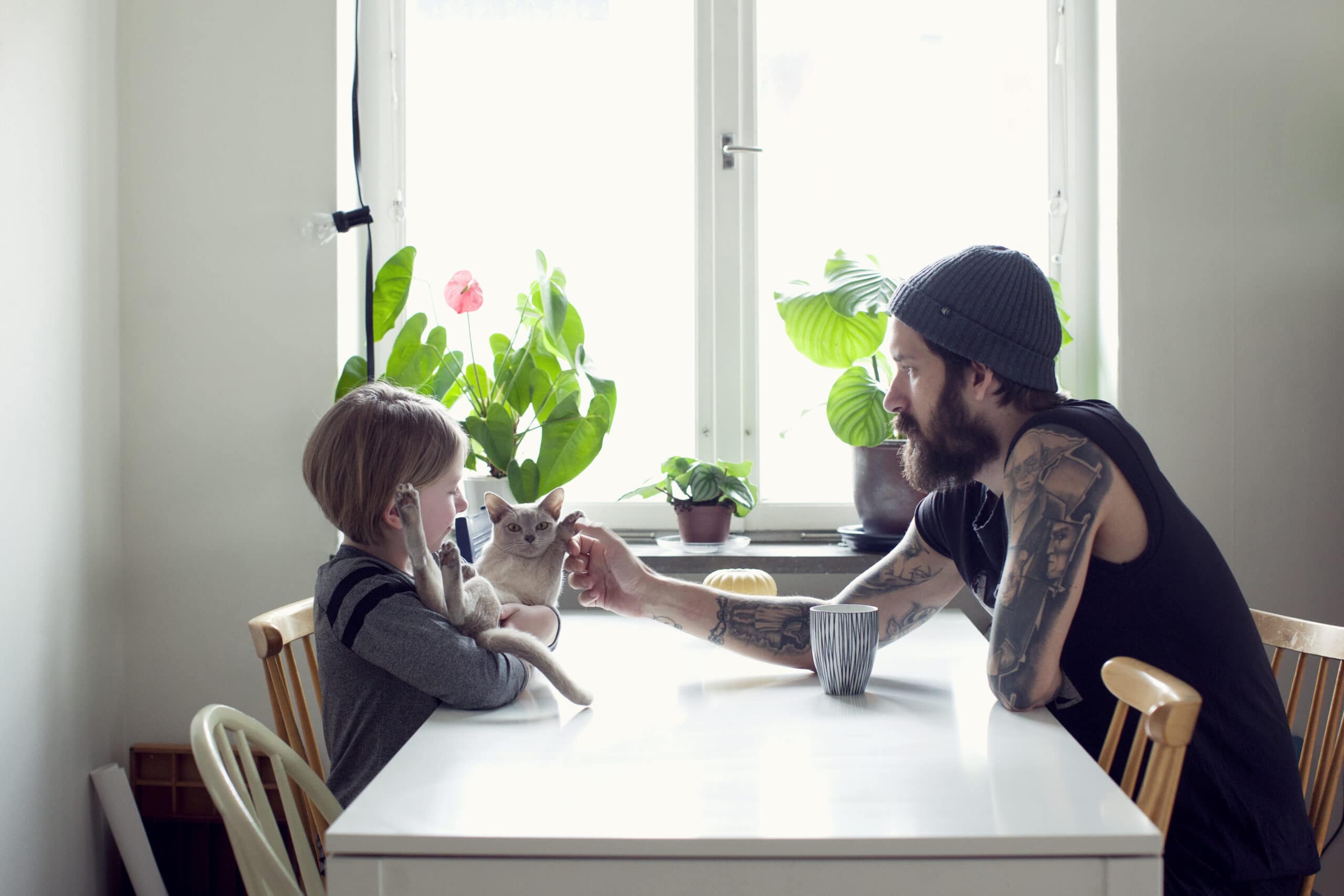 En liten gutt og pappaen hans sitter ved et spisebord