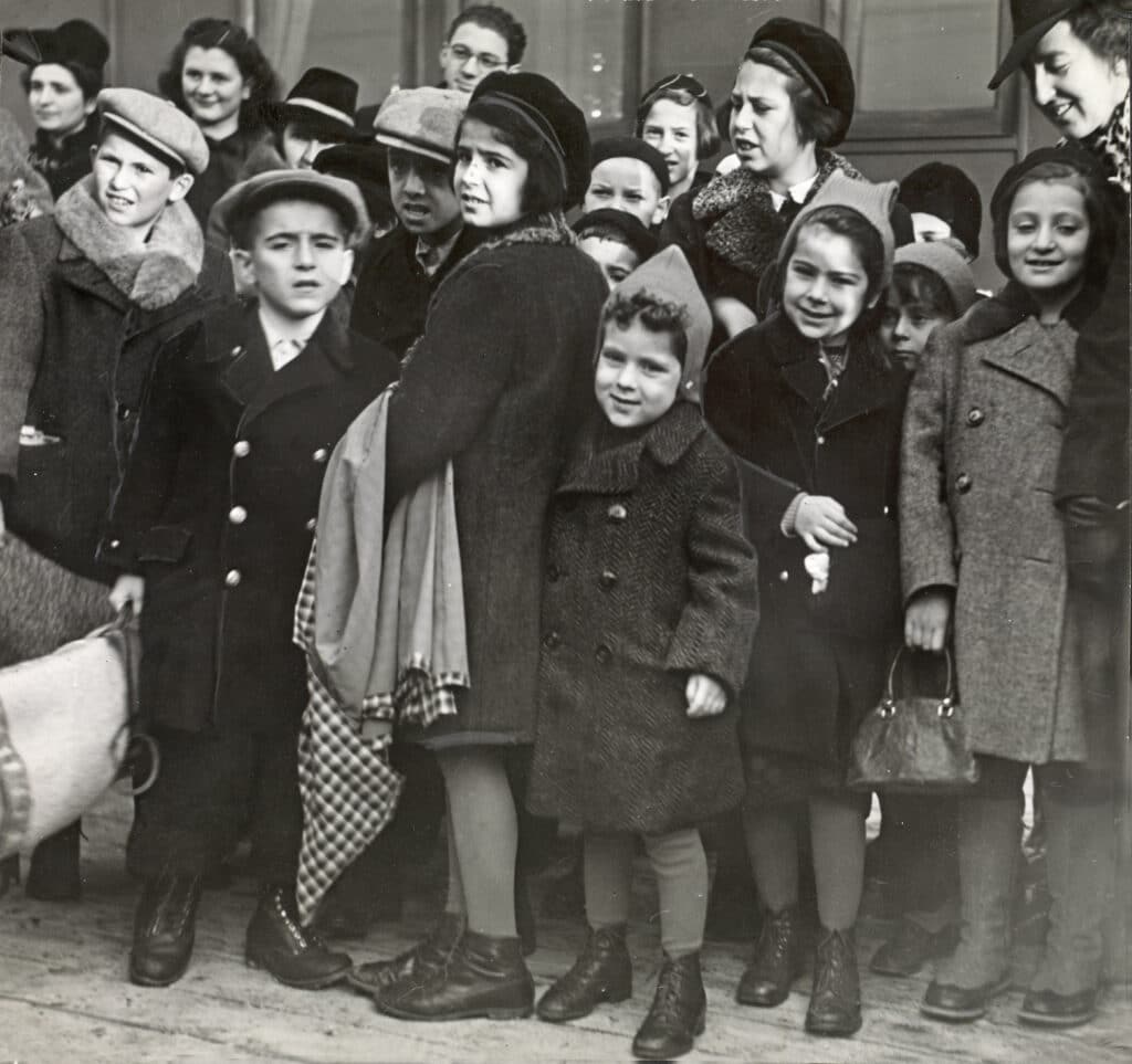 Historisk sort-hvitt-foto av en gruppe barn som står tett.