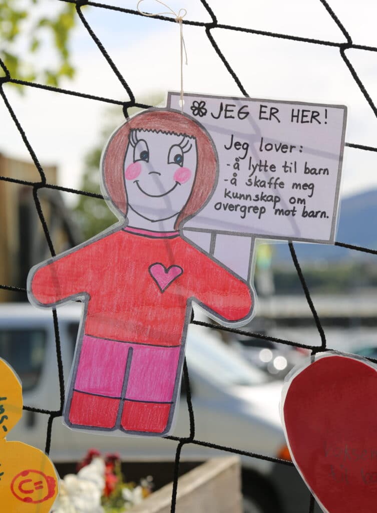 En tegning av en figur som smiler med en snakkeboble der det står "jeg er her, jeg lover å lytte til barn og skaffe meg kunnskap om overgrep mot barn".