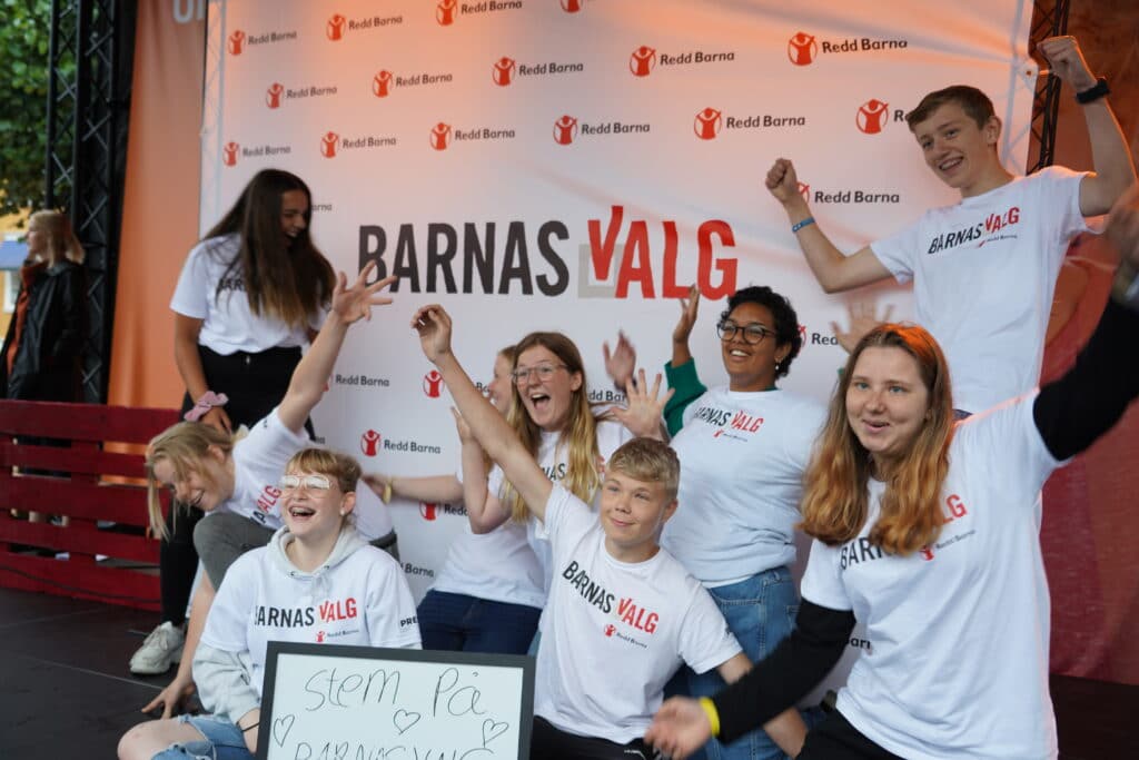 Ungdommer med Barnas Valg-t-skjorter jubler mot kamera under Arendalsuka