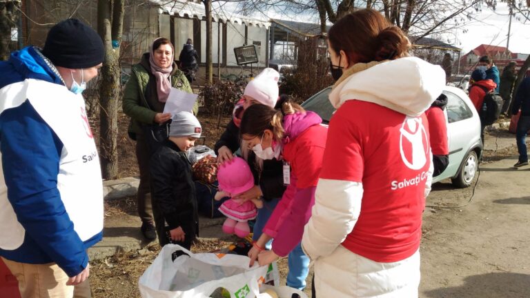 En Redd Barna-ansatt står og deler ut nødvendigheter til flyktninger som har kommet over grensen fra Ukraina