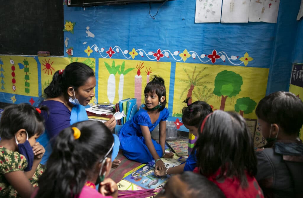 Foto av barn og voksen som leser bok sammen fra Bangladesh. TV-aksjonen 2023 Redd Barna.