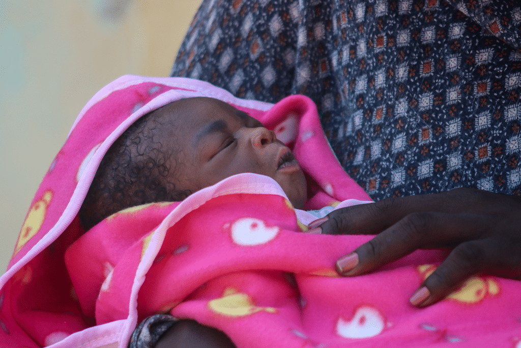 Fotografi av baby i mors fang i Sudan.