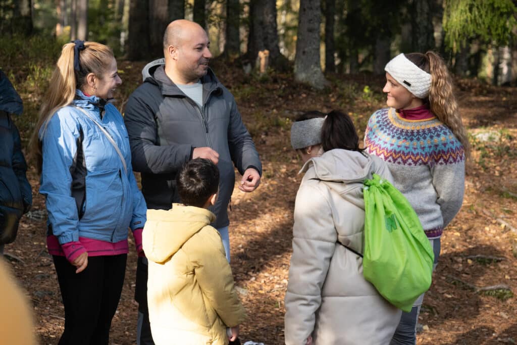 Frivillige og barn står sammen i skogen