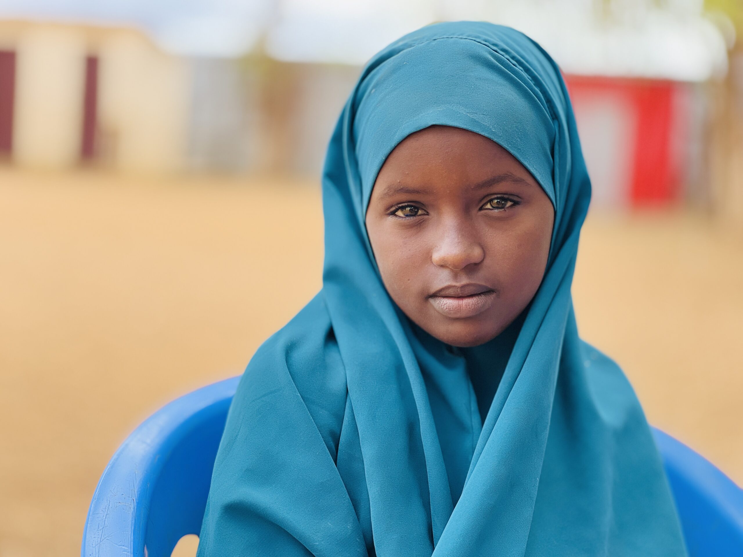 Sundus (13) fra Somalia, sitter på en stol og ser inn i kamera.