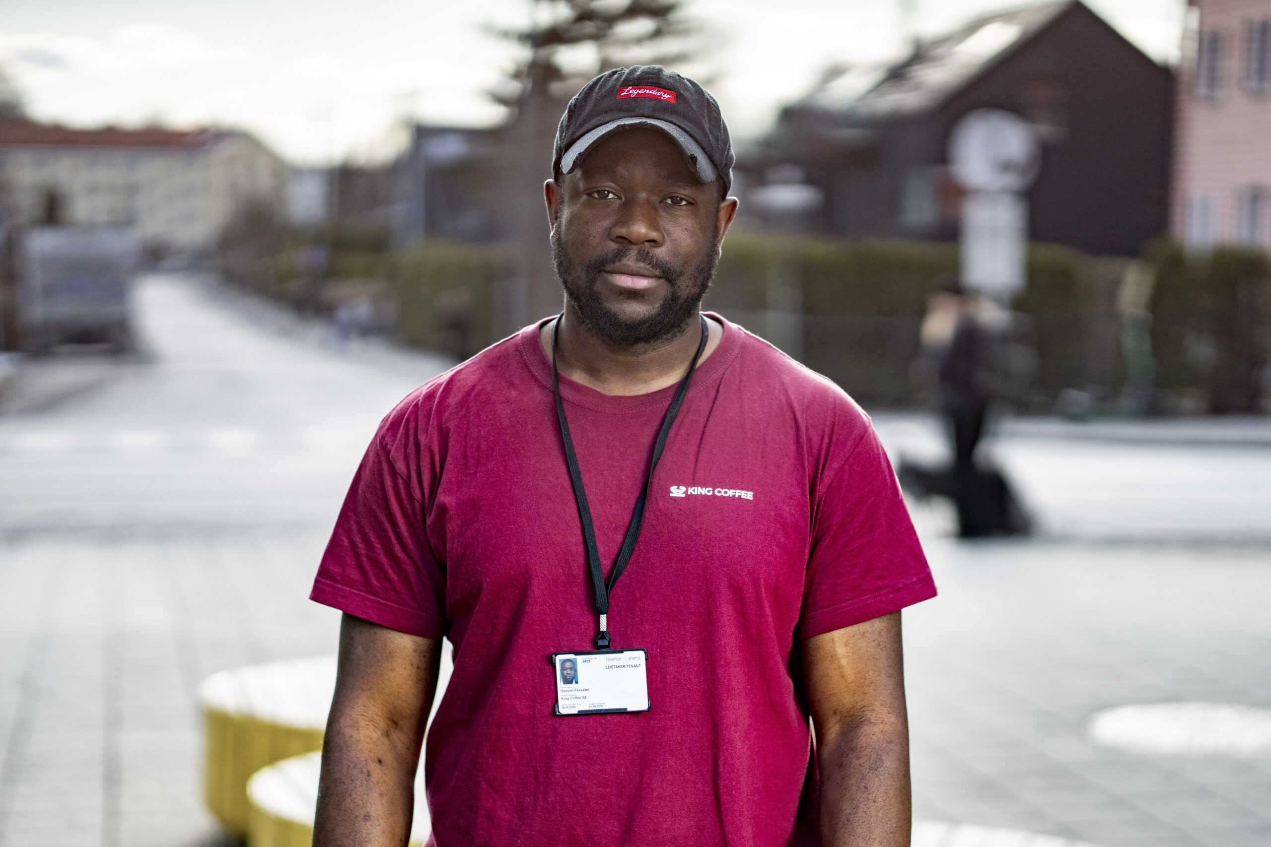 Hashim, i rød t-skjorte, står ute på gaten og ser alvorlig inn i kamera.