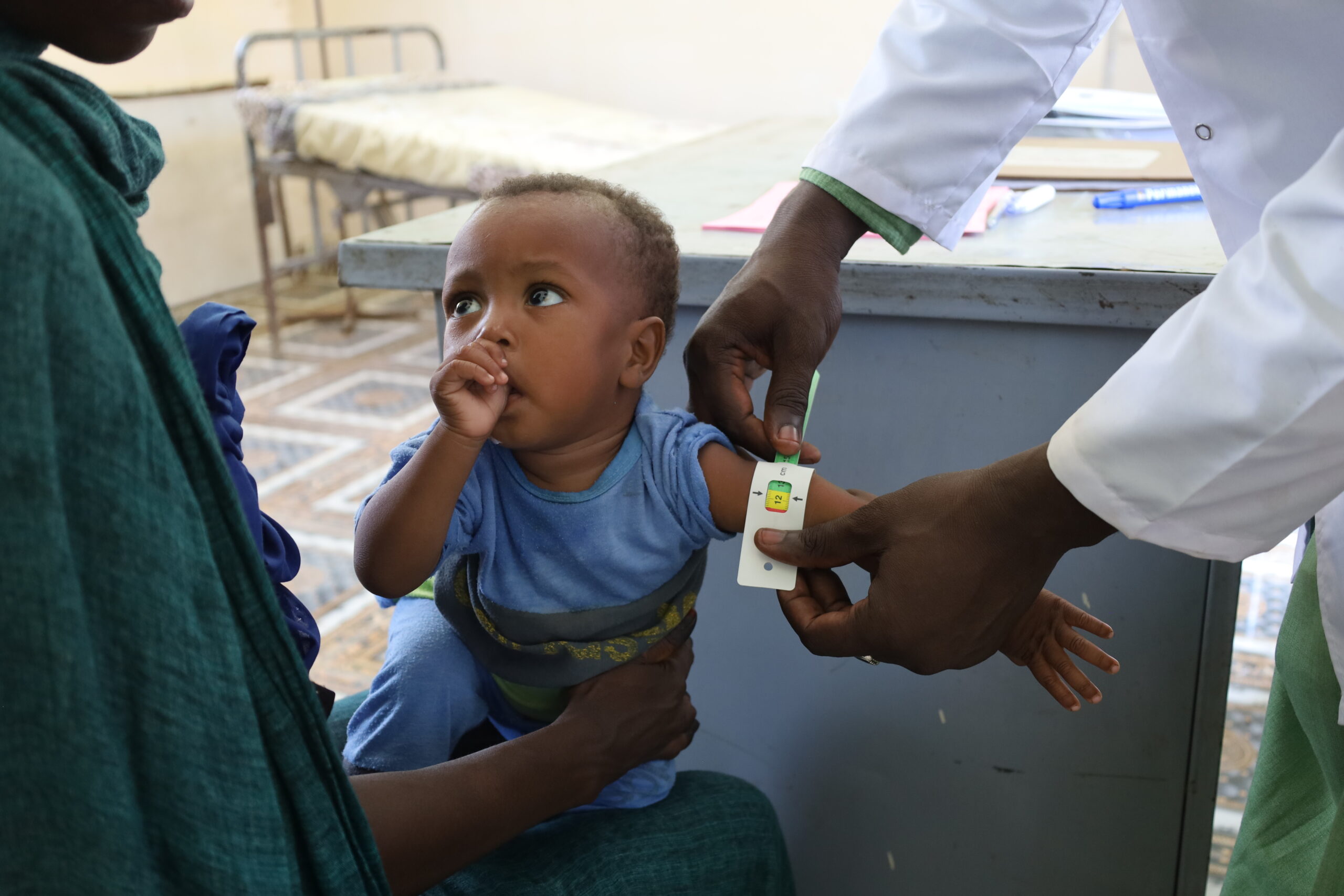 En helsearbeider fra Redd Barna måler Bashirs armomkrets på helsesenteret i Sudan.