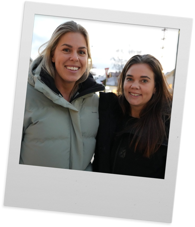 Polaroidbilde av Elise og Hanne som står ute i boblejakker og smiler til kamera. 