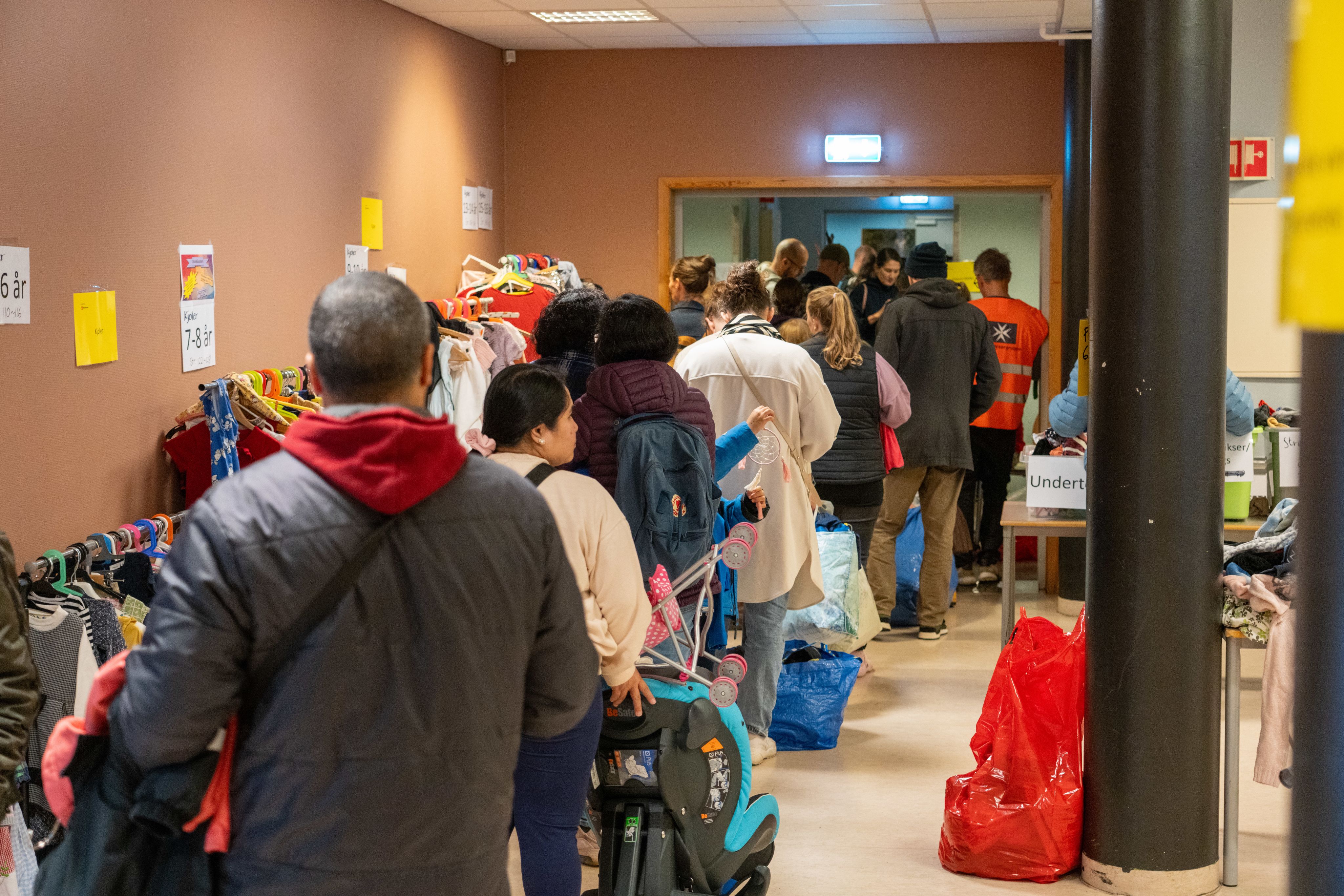 En lang kø av mennesker strekker seg gjennom rommen