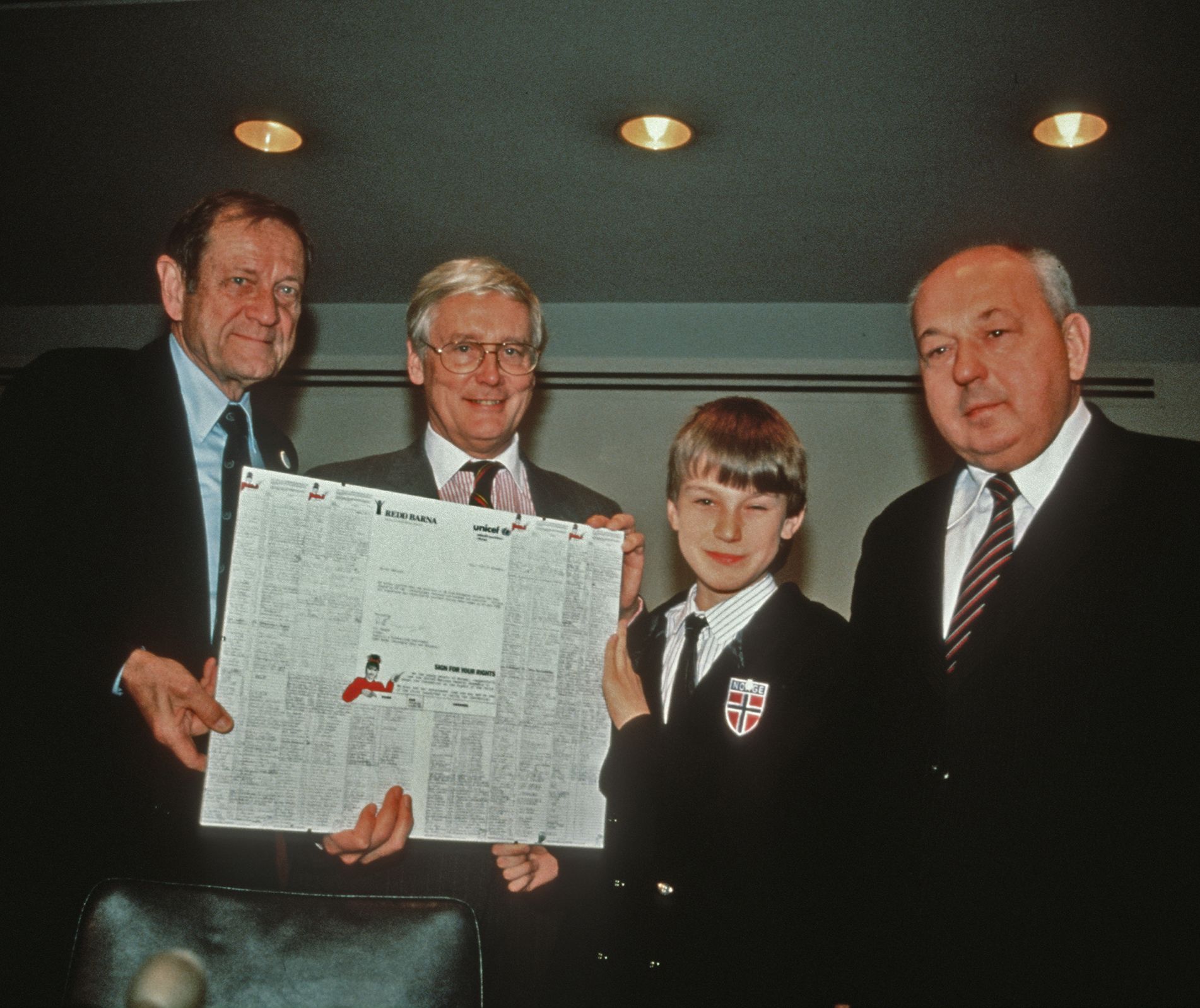 Gammelt fargefoto viser en blunkende Martin Sandberg (12) som overleverte hilsninger fra norske barn til FN i New York da barnekonvensjonen ble vedtatt 20. november 1989. Han har følge av tre voksne menn.