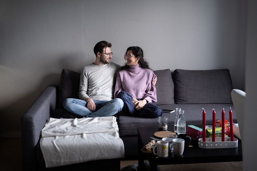 Et par sitter i en sofa og ser på hverandre.