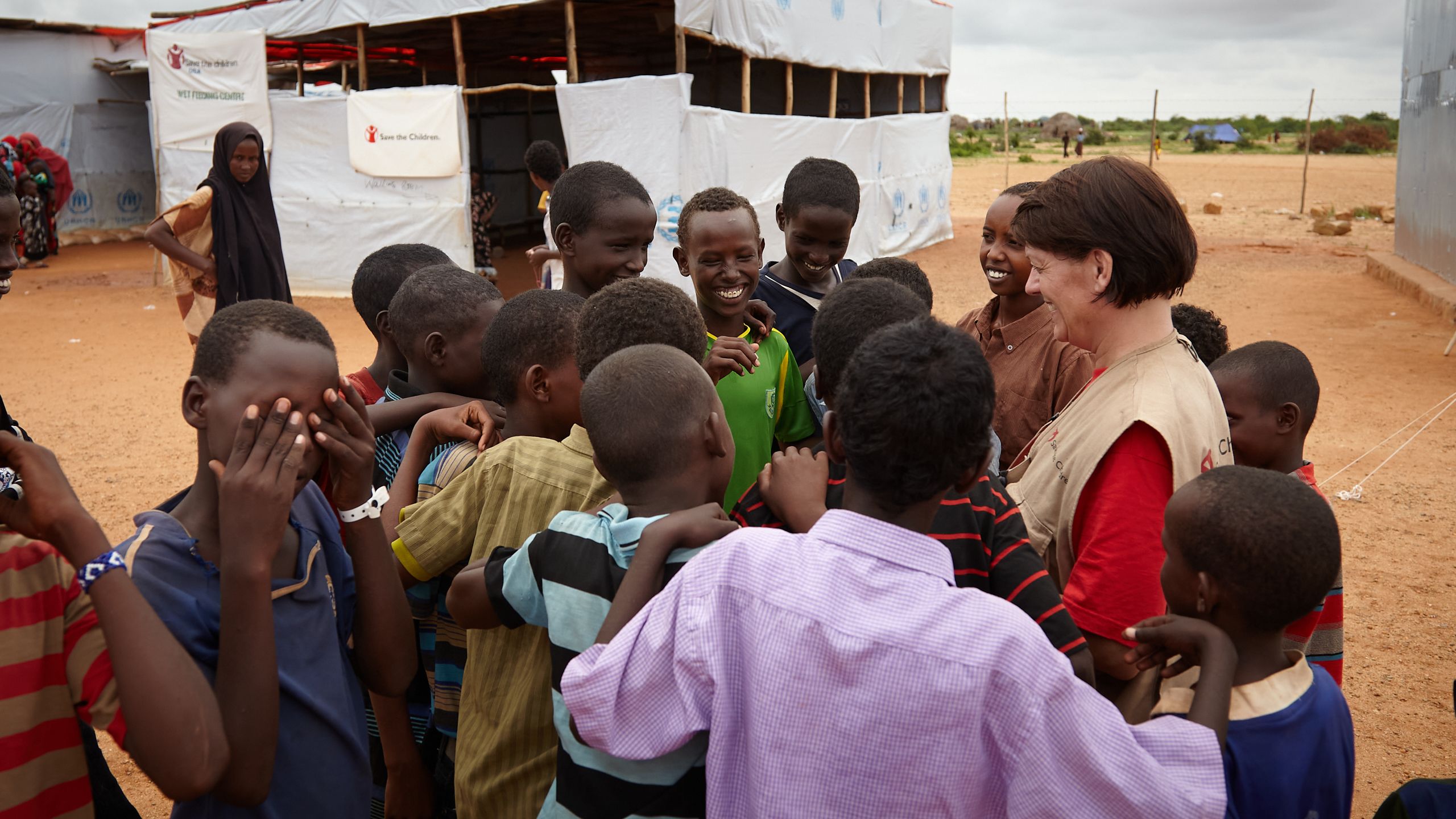 Bilde av Randi Saure som møteer barn i en afrikansk flyktningleir.