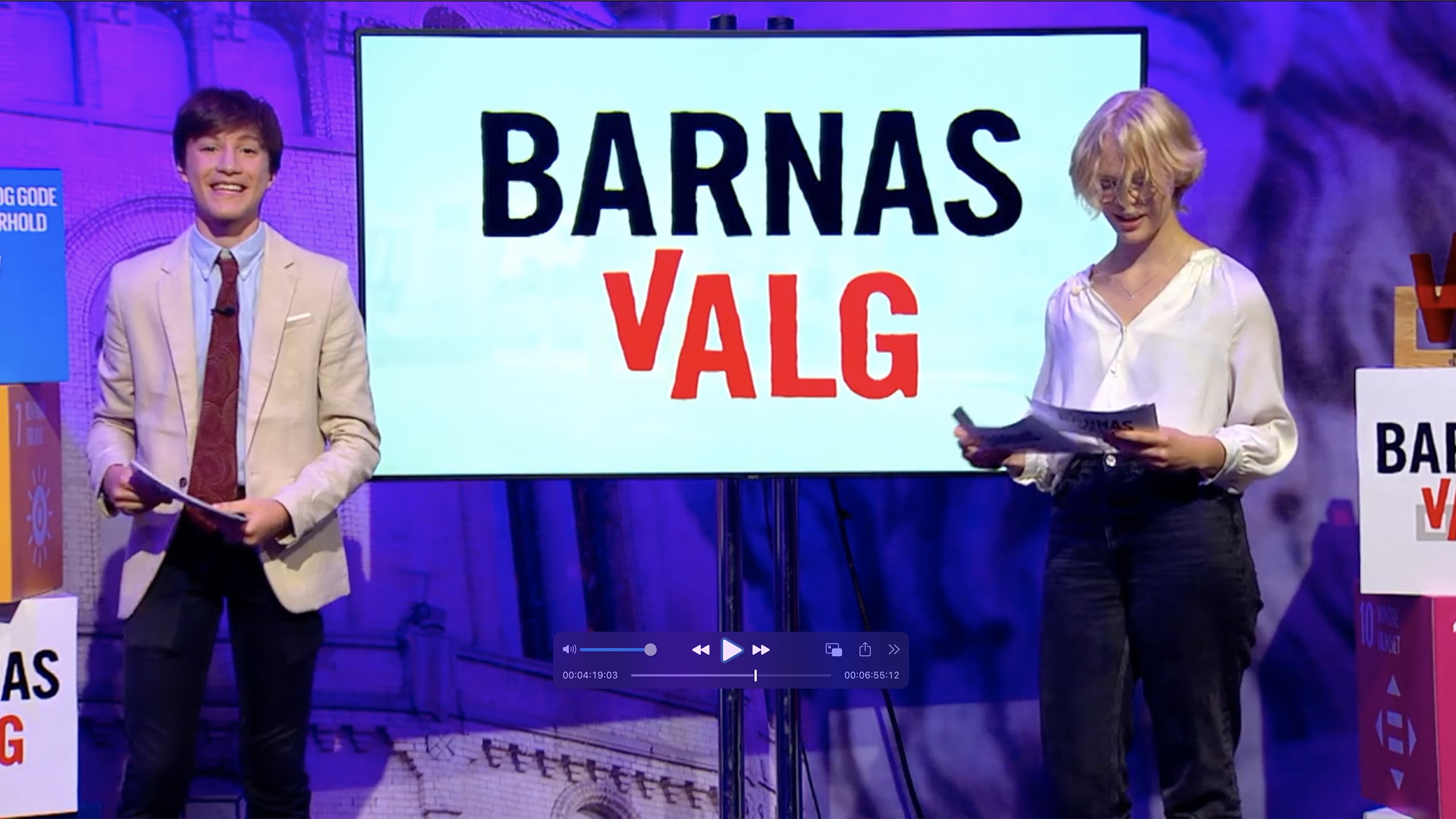 To unge programmledere foran en TV der det sår Barnas valg.